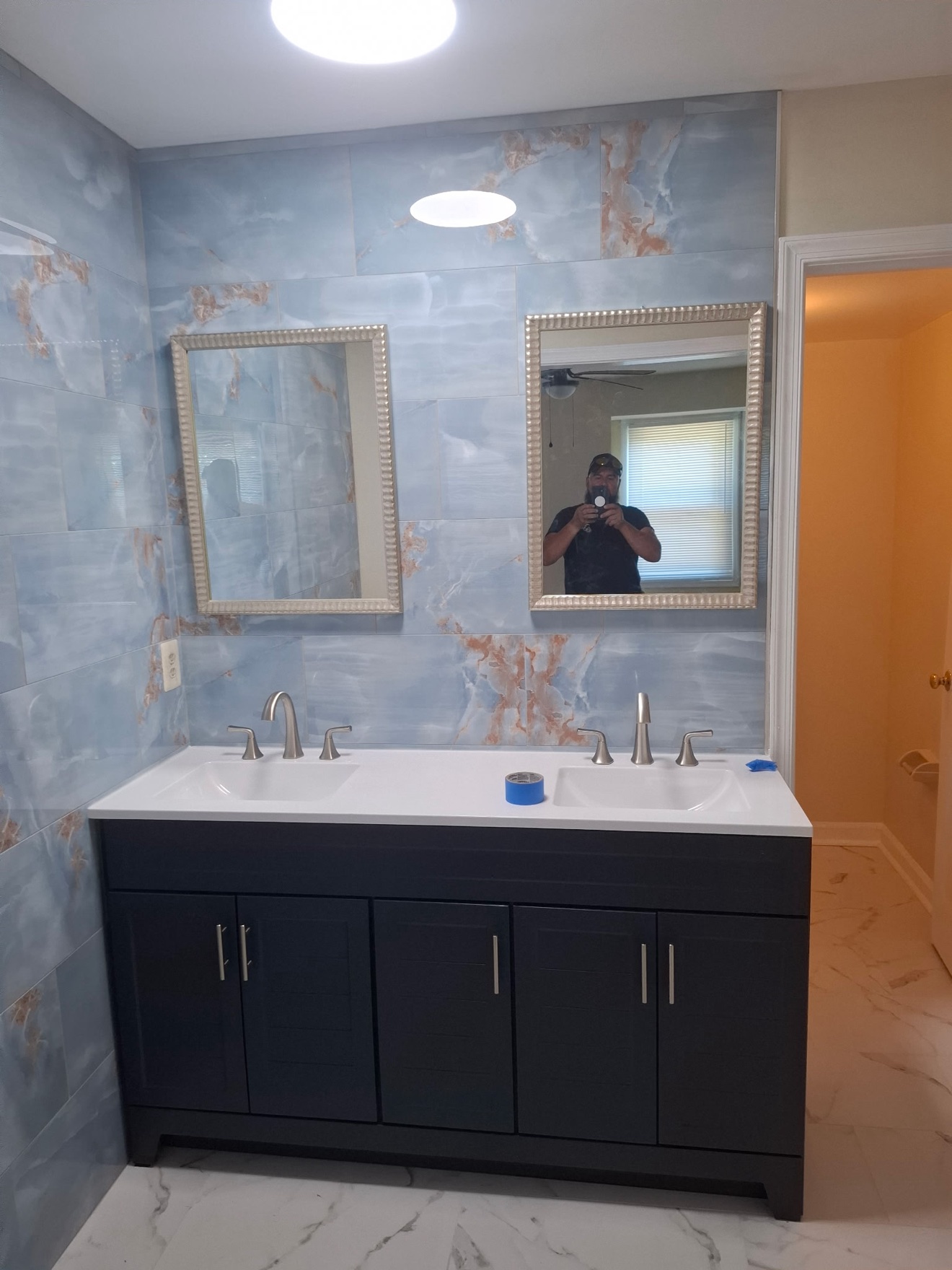 Francisco's finished bathroom remodel with blue marble-look tile and a double vanity