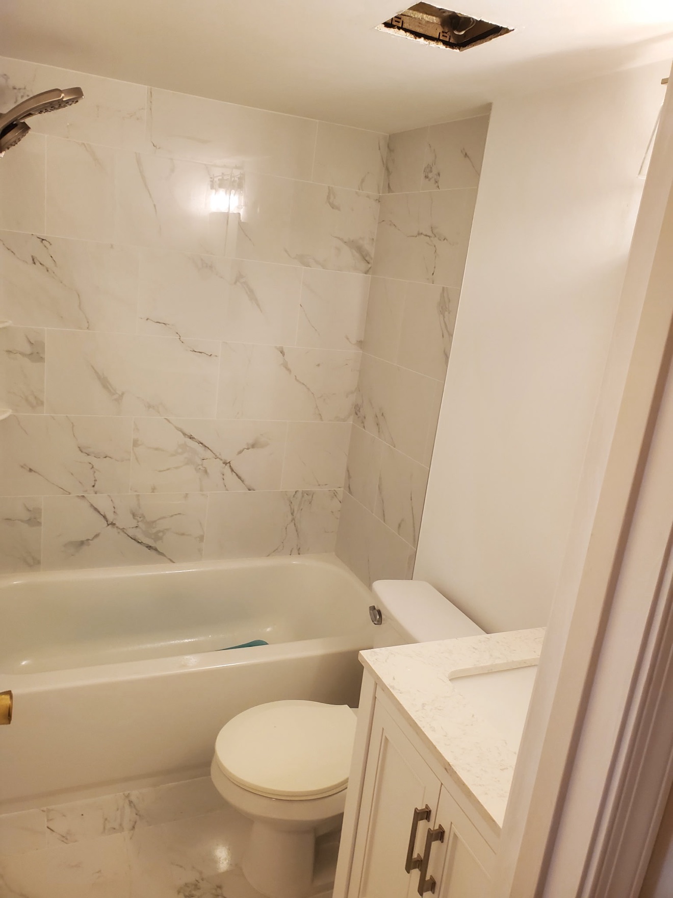 Finished white marble-look tile tub and shower