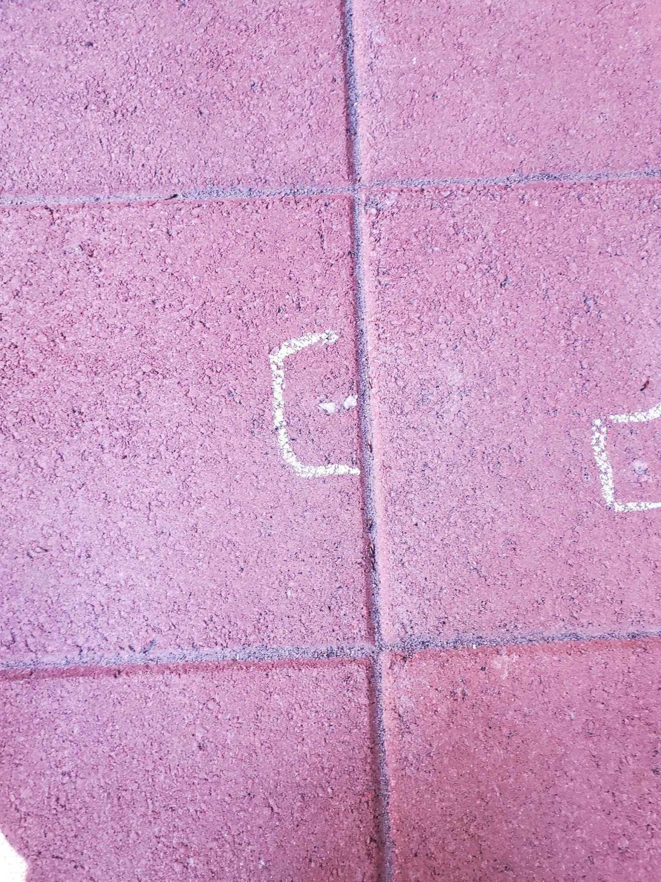 Red pavers being laid with chalk layout marks