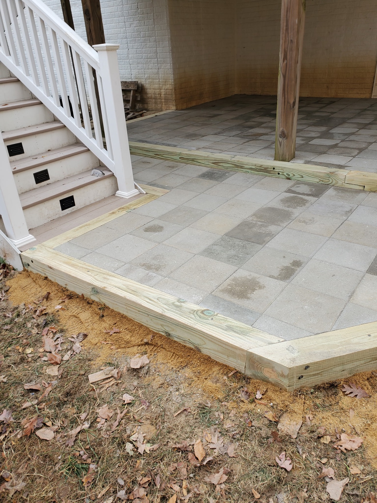 Paver patio with a timber border and lighted steps