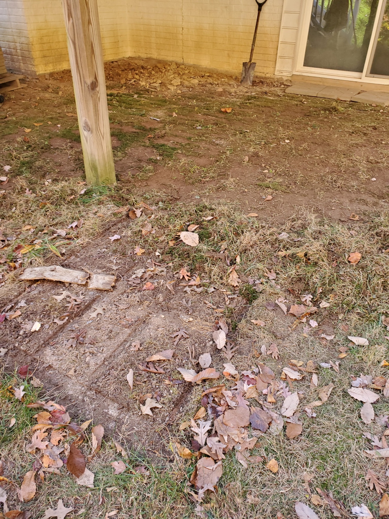 Bare dirt yard under a deck before the patio build