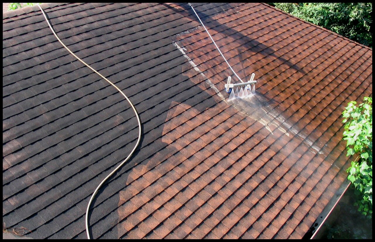 Roof being pressure washed, half clean and half dirty
